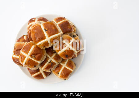 Un piatto pieno di pane appena sfornato, pasqua, hot cross panini isolato su un sfondo bianco. una vista dall'alto guardando verso il basso. Foto Stock