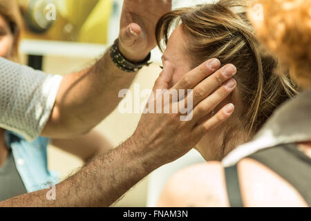 Professional cosmetologo applicando anti-invecchiamento unguenti sul viso femminile, vicino agli occhi Foto Stock