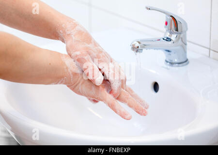 Il lavaggio delle mani con sapone in acqua corrente. Igiene e pulizia delle mani. Foto Stock