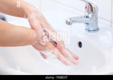 Il lavaggio delle mani con sapone in acqua corrente. Igiene e pulizia delle mani Foto Stock