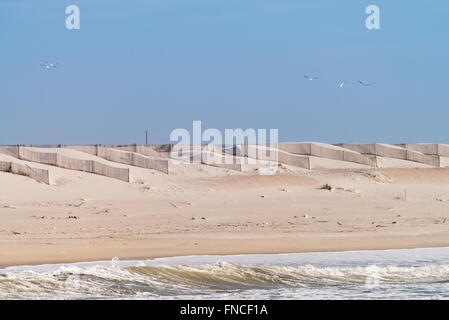 Spiaggia di sabbia e dune con giacca a vento bastone di legno recinzioni in Costa Nova, Aveiro - Portogallo. Foto Stock
