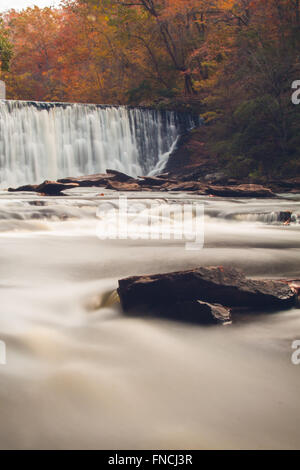 Soft slow moving creek al di sotto di una diga girato con una lunga esposizione Foto Stock