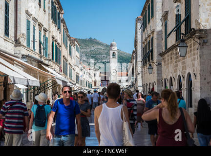 I turisti a Stradun (o Placa) - calcare-pedonale pavimentato street nella Città Vecchia di Dubrovnik, Croazia. Vista con Torre Campanaria Foto Stock