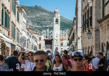 I turisti a Stradun (o Placa) - calcare-pedonale pavimentato street nella Città Vecchia di Dubrovnik, Croazia. Vista con Torre Campanaria Foto Stock