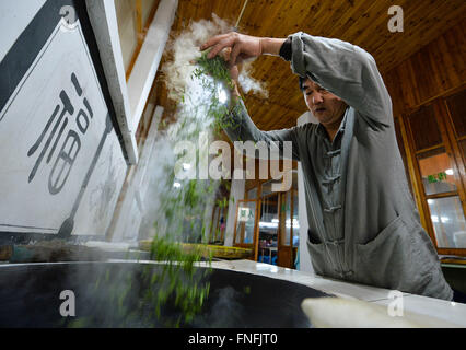 (160315) -- SUZHOU, Marzo 15, 2016 (Xinhua) -- Yan Jielong cuoce Biluochun tè nella città di Dongshan, Suzhou City di oriente cinese della provincia di Jiangsu, Marzo 14, 2016. Yan Jielong, 53 anni, erede dell'antica tecnica di realizzazione di tè cinese Biluochun, ha imparato che la specialità poiché era 16 anni. Che richiedono elevati standard di realizzazione tecnica, Biluochun il tè è la specialità di Dongshan città dove la gente che conoscono l'antica tecnica di realizzazione sono per la maggior parte nel loro 50s. Yan e altri eredi hanno preso il video del loro metodo e spero possano un giorno di aprire una scuola per esso e passare sul techni Foto Stock