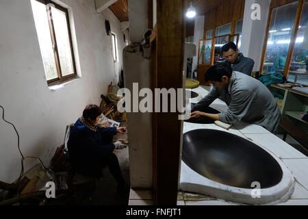 (160315) -- SUZHOU, Marzo 15, 2016 (Xinhua) -- Yan Jielong (1R) cuoce Biluochun tè nella città di Dongshan, Suzhou City di oriente cinese della provincia di Jiangsu, Marzo 14, 2016. Yan Jielong, 53 anni, erede dell'antica tecnica di realizzazione di tè cinese Biluochun, ha imparato che la specialità poiché era 16 anni. Che richiedono elevati standard di realizzazione tecnica, Biluochun il tè è la specialità di Dongshan città dove la gente che conoscono l'antica tecnica di realizzazione sono per la maggior parte nel loro 50s. Yan e altri eredi hanno preso il video del loro metodo e spero possano un giorno di aprire una scuola per esso e passare su th Foto Stock