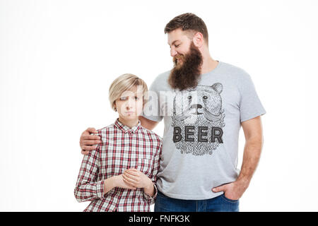 Felice bello padre barbuto in piedi e abbracciando la figlia su sfondo bianco Foto Stock