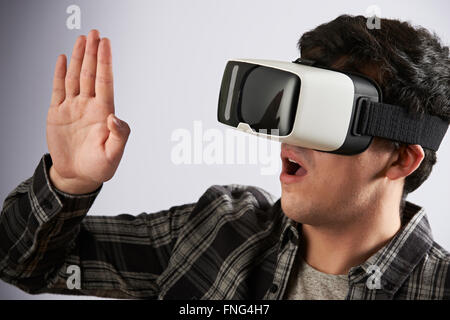 Giovane uomo che indossa la realtà virtuale auricolare Foto Stock