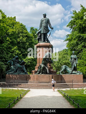 Senior uomo guardando il bronzo Bismarck memorial nella pubblica Tiergarten park in estate, Berlino Foto Stock