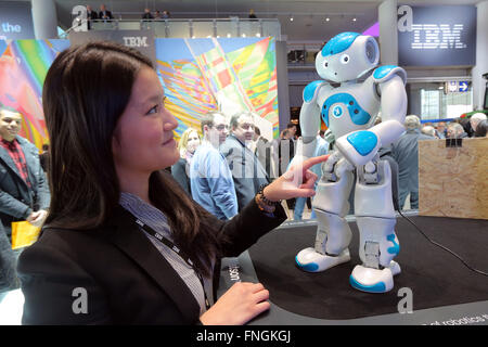 Uno stand hostess tocca un NAO robot Watson presso la IBM stand al CeBIT 2016 tecnologia digitale fiera di Hannover in Gerrmany Foto Stock