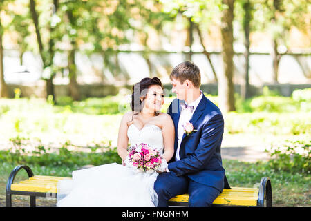 Matrimonio sposa e lo sposo su un banco di lavoro con la natura paesaggio paesaggio sullo sfondo Foto Stock