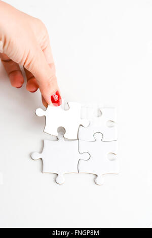 Donna raccordo di mano destra pezzo del puzzle suggerendo di business networking concept Foto Stock