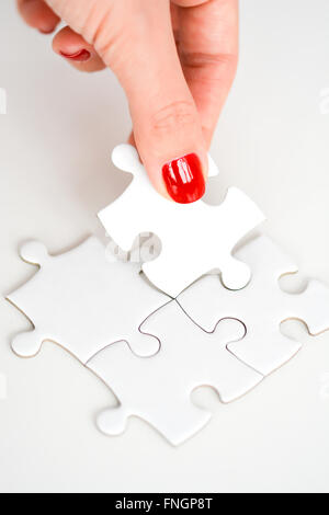 Donna raccordo di mano destra pezzo del puzzle suggerendo di business networking concept Foto Stock