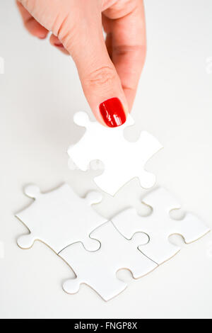 Donna raccordo di mano destra pezzo del puzzle suggerendo di business networking concept Foto Stock