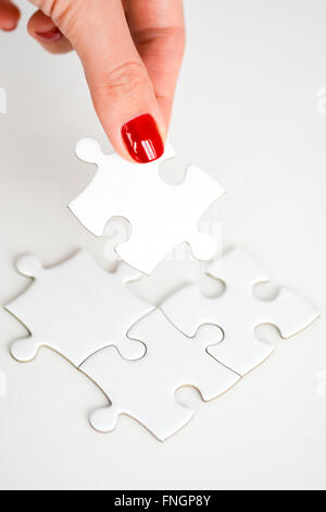 Donna raccordo di mano destra pezzo del puzzle suggerendo di business networking concept Foto Stock