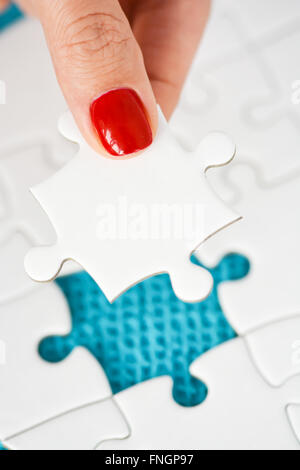 Donna raccordo di mano destra pezzo del puzzle suggerendo di business networking concept Foto Stock