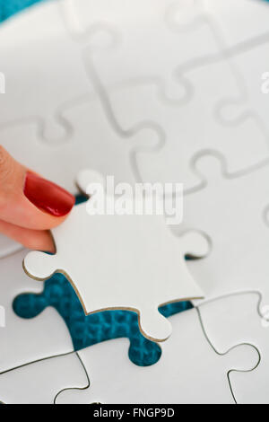 Donna raccordo di mano destra pezzo del puzzle suggerendo di business networking concept Foto Stock