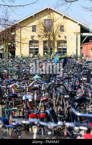 Lund, Svezia - 12 Marzo 2016: Persona con zaino in piedi tra lotti di biciclette al bike Parcheggio al di fuori della stazione st Foto Stock