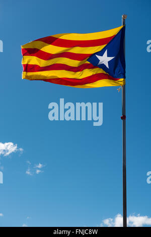 Sventola bandiera della Catalogna (estelada blu) oltre il cielo blu sullo sfondo Foto Stock