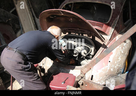 Nablus, Territori palestinesi. Xi Febbraio, 2016. Un meccanico controlla il motore di una VW Beetle in una riparazione auto shop a Nablus, Territori palestinesi, 11 febbraio 2016. Un crescente numero di palestinesi stanno scoprendo il classico auto per se stessi. Foto: DAVID EHL/dpa/Alamy Live News Foto Stock