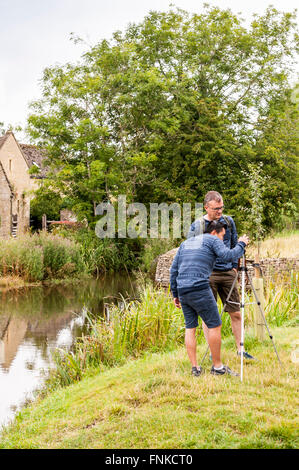 I turisti per scattare delle foto in Lower Slaughter , Gloucestershire , Inghilterra , Inghilterra , Regno Unito Foto Stock