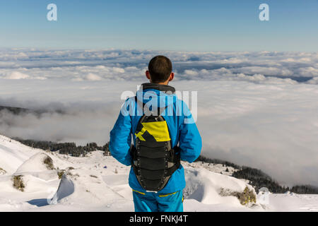 Sciatore Freestyle è guardando dalla sommità di un picco di montagna Vitosha covored in nubi. Egli partecipa a un freestyle com Foto Stock