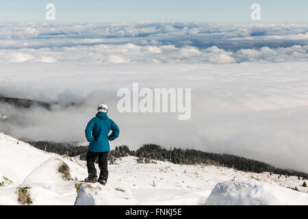 Sciatore Freestyle è guardando dalla sommità di un picco di montagna Vitosha covored in nubi. Egli partecipa a un freestyle com Foto Stock