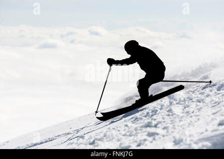 La silhouette di un sciatore freestyle sci presso la sommità di un picco innevato del Monte Vitosha coperto di nuvole. Egli partecipa Foto Stock