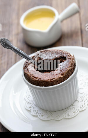 Appena sfornato souffle al cioccolato con crema italienne, francese dessert Foto Stock