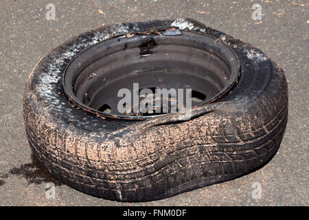 Sporco pneumatico danneggiato e rim dopo aver colpito cordolo Foto Stock