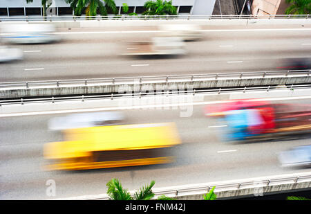 Camion e automobili su una autostrada a Singapore. Sfocatura del movimento Foto Stock