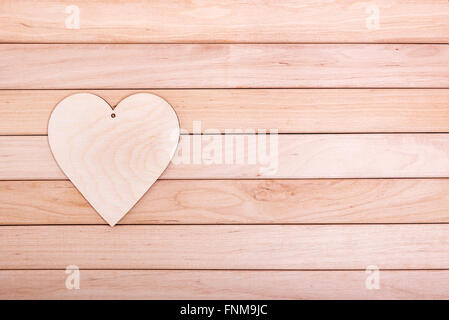 Cuore di legno su tavole di legno. Foto Stock