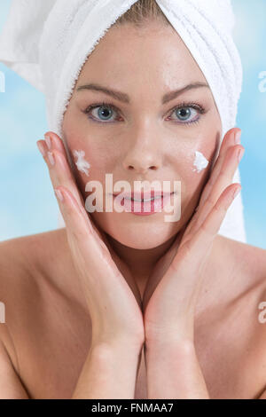 Bella donna faccia con crema idratante. Foto Stock