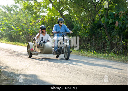 Presidente Rafael Correa e show host Peter Greenberg guidare una motocicletta vintage con un sidecar nel cacao regione durante le riprese di Ecuador: Royal Tour. Foto Stock