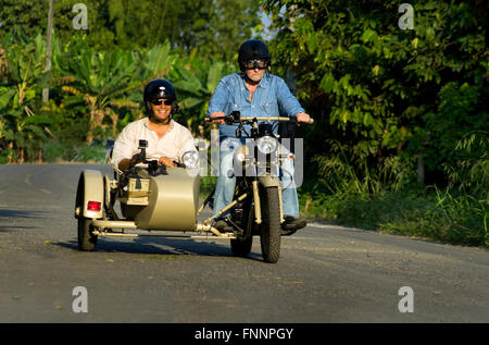 Presidente Correa e show host Peter Greenberg ride su una motocicletta vintage con un sidecar nella regione di Cacao durante le riprese di Ecuador: Royal Tour. Foto Stock