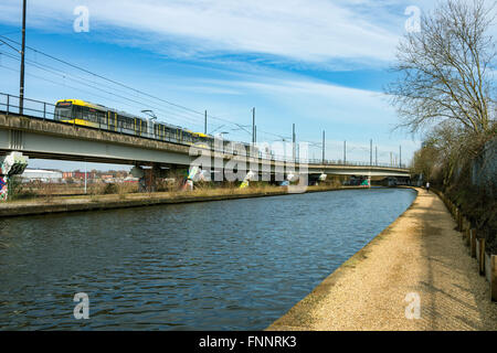 Tram Metrolink vicino al Pomona stop sul viadotto accanto al Bridgewater Canal, Manchester, Inghilterra, Regno Unito Foto Stock