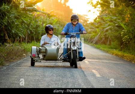 Presidente Rafael Correa e show host Peter Greenberg guidare una motocicletta vintage con un sidecar nel cacao regione durante le riprese di Ecuador: Royal Tour. Foto Stock