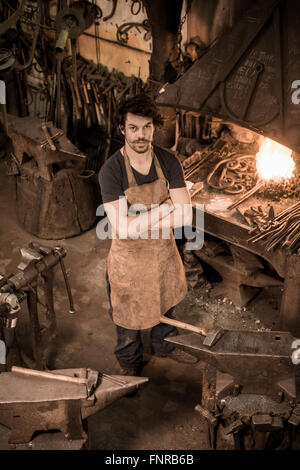 Ironworker forgiatura del ferro caldo in officina Foto Stock