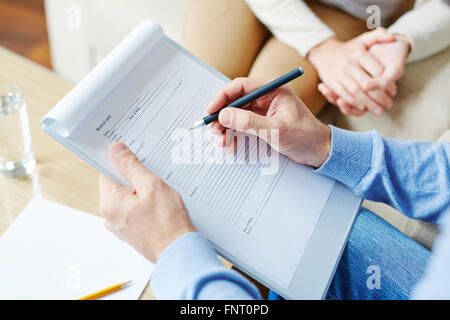 Close-up dei maschi di mani rendendo note nel documento Foto Stock