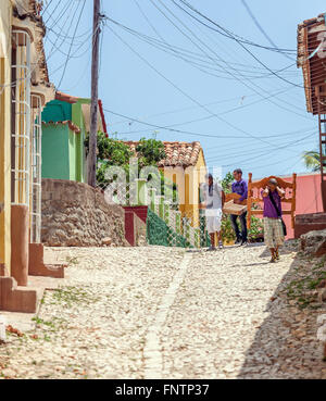 TRINIDAD, CUBA - MARZO 30, 2012: strade della città vecchia con i nativi di adolescenti che trasportano bed solo uso editoriale. Foto Stock