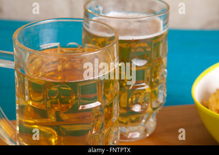 Patate fritte e due tazze di birra sul tavolo Foto Stock