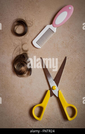 Vista dall'alto di un pettine, i capelli e la cesoia di taglio. Foto Stock