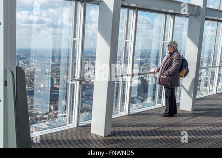 Una donna guarda la vista dalla Shard, London, Regno Unito Foto Stock