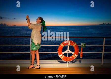 Ragazza turistica fare foto al dock di Paul Gauguin crociera, Isole della Società, Tuamotus arcipelago, Polinesia francese, Sud Paci Foto Stock