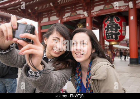 Due giovani donne al Tempio di Sensoji e tourist area dello shopping. Foto Stock