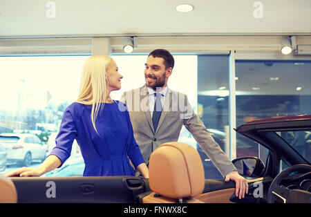 Coppia felice l'acquisto di auto in auto show o salon Foto Stock