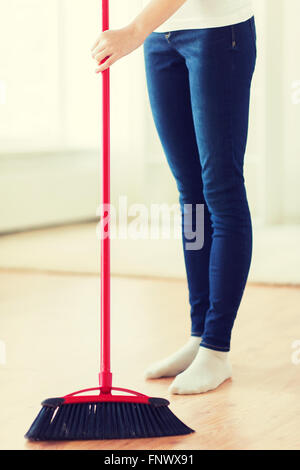 Close up della donna le gambe con la scopa piano di spazzamento Foto Stock