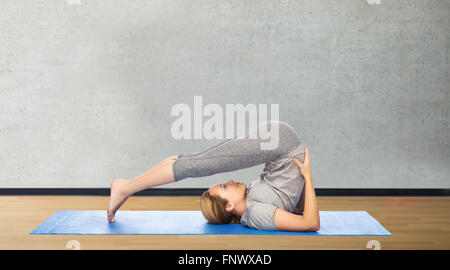 Donna fare yoga in aratro pone sul tappeto Foto Stock