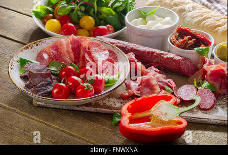 Tradizionale antipasto italiano su una tavola di legno. Messa a fuoco selettiva Foto Stock