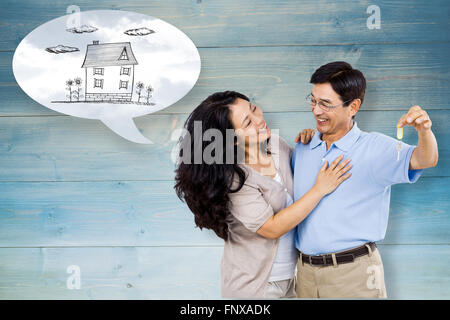 Immagine composita della coppia sorridente in possesso di un set di chiavi Foto Stock